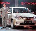 Toyota Motors President Akio Toyoda standing beside the companys car, Etios. AP