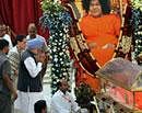 Prime Minister Manmohan Singh and Congress President Sonia Gandhi paying their last respect to Sri Sathya Sai Baba at the Kulwant Hall of Prashanthi Nilayam in Puttaparthi in Andhra Pradesh on Tuesday. PTI