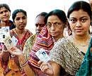 Powered by democracy: Women flash their voter identity cards as they stand in a queue to cast their votes during the sixth and final phase of the West Bengal Assembly polls at Barikula in Bankura district on Tuesday. PTI
