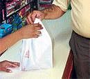 Habit A shopkeeper handing over a 40-micron bag. DH photo by: Poorna Uthappa and Sanya Sood