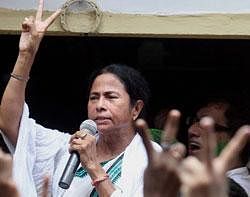 Trinamool Congress supremo Mamata Banerjee showing victory sign while addressing her party workers and supporters at her Kalighat residence in Kolkata on Friday. PTI