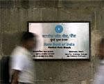 People walk in front of a signboard displayed at the head office of State Bank of India in Mumbai - Reuters photo