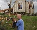 A man carries a young boy who was rescued after being trapped in his home after a tornado hit Joplin, Mo. on Sunday evening. AP