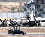 Pakistani troops gather next to a burnt plane inside the naval aviation base following an attack by militants in Karachi on Monday. AP
