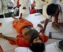 A doctor checks the health of Baba Ramdev on the sixth day of his hunger-strike at Patanjali Yogpeeth in Haridwar on Thursday. PTI