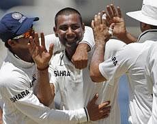 Praveen Kumar, centre, is congratulated by teammates Suresh Raina, left, and VVS Laxman after taking  a  wicket . AP File Photo