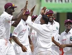 West Indies' Darren Sammy, left, celebrates with Shivnarine Chanderpaul, front right, after Chanderpaul took the wicket of India's VVS Laxman, not shown, who was out stumped during the third day of the third cricket Test match in Roseau, Dominica, Friday, AP