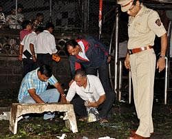 Security personnel and investigators gather at a bomb blast site in the Dadar District of Mumbai on Wednesday. AFP