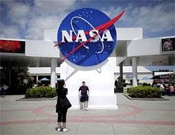 Tourists take pictures of a NASA sign at the Kennedy Space Center visitors complex in Cape Canaveral, Florida April 14, 2010. Reuters