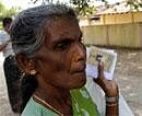 A Sri Lankan ethnic Tamil voter holds her identity and polling card as she waits to cast her vote outside a polling station in Jaffna, Sri Lanka on Saturday. AP