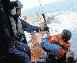 One of the 30 crew members being winched onto a Navy helicopter that was pressed in for rescue operations as the cargo ship, MV Rak, sinks in the Arabian Sea off the coast of  Mumbai on Thursday. AP