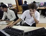 Stock brokers watch the Bombay Stock Exchange (BSE) index on his trading terminal in Mumbai. AP Photo