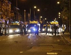 Police officers form a barrier across a road to block it from a group of youths, in Liverpool August 9, 2011. Reuters