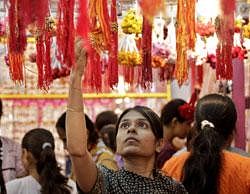 An Indian woman looks at a rakhi, a sacred thread tied on the wrist, at a shop ahead of Raksha Bandhan festival in Ahmadabad- AP Photo