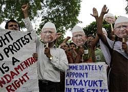 Protestors hold cut-outs of anti-corruption activist Anna Hazare and shout slogans during a protest in support of Hazare's fight against corruption in Ahmedabad on Wednesday. AP