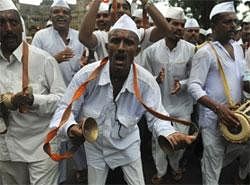 Dabbawalas dance as they chant  hymns during a rally in support of social activist Anna Hazare in Mumbai on Friday. AFP