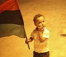 Mustafa Saad, 5, holds a pre-Moammar Gadhafi flag during celebrations of the capture in Tripoli of his son and one-time heir apparent, Seif al-Islam, at the rebel-held town of Benghazi, Libya, early Monday. AP Photo