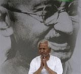 India's anti-corruption activist Anna Hazare sits in front of a giant portrait of Mahatma Gandhi on the ninth day of his hunger strike, in New Delhi, India, Wednesday, Aug. 24, 2011. India's government worked Wednesday to end Hazare's hunger strike protest, calling for all the parties in Parliament to debate his demands for stringent anti-corruption legislation. AP Photo