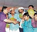 In High spirits: Former Lokayukta Justice N Santhosh Hegde offers tender coconut to those who were on hunger strike at the Freedom Park.  DH Photo