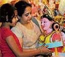A woman and her daughter marvel at an idol of Gowri at a shop in the City. DH Photo