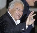 Dominique Strauss-Kahn, former head of the International Monetary Fund, waves upon his arrival at Roissy airport, north of Paris, France, Sunday. AP