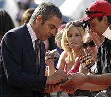 Rowan Atkinson signs autographs for fans as he arrives at the World Premier of ''Johnny English Reborn'' in Sydney, Australia, Sunday, AP