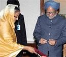Prime Minister Manmohan Singh after signing the visitors' book at PMO in Dhaka on Tuesday as  Bangladeshi counterpart Sheikh Hasina looks on. PTI