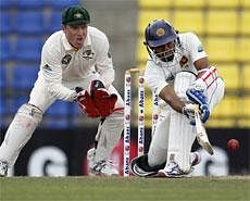 Sri Lankan batsman Tillakaratne Dilshan plays a shot as Australia's wicket keeper Brad Haddin, left, looks on during the fourth day's play of the second test cricket match between Australia and Sri Lanka in Pallekele, Sri Lanka, Sunday, AP
