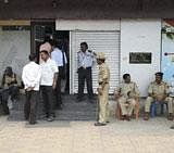 Policemen guard a bank during raid by a team of CBI to search lockers owned by Srinivas Reddy, brother-in-law of former Karnataka Minister G Janardhan Reddy in Bellary on Saturday. PTI Photo