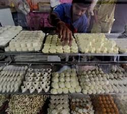 A worker arranges sweets inside a shop in Kolkata. Reuters