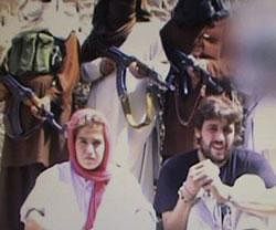 This is an image taken from a militant video which emerged Tuesday Oct. 25, 211 and shows what is believed to be a Swiss couple, abducted by the Pakistani Taliban in Baluchistan in July this year. In the video the Swiss tourists held by the Pakistani Taliban appealed to the Pakistani government to release Taliban prisoners in exchange for the two of them. AP is not able to independently verify the authenticity of the video. The face of one of the militants at right was pixellated by the group. AP