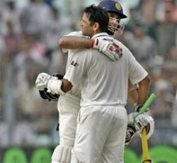 Indian batsman V.V.S. Laxman, back, congratulates teammate Rahul Dravid for scoring hundred runs against West Indies during the first day of their second cricket test match in Kolkata, India, Monday, Nov. 14, 2011. AP Photo