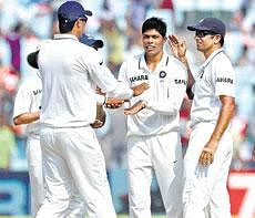 Umesh Yadav is congratulated by his team-mates after nailing a West Indian batsman. AFP