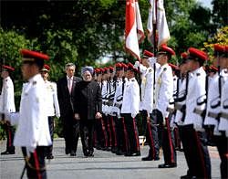 Prime Minister Manmohan Singh accompanied by Singapore Prime Minister Lee Hsien Loong, center right, inspects a guard of honor during a welcome ceremony at the Istana in Singapore, Sunday. AP