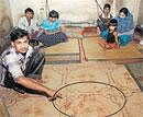 Family members of Mukhtar Hussain sit dazed as one of them points to blood stains on the floor at his house in  Kumbarpet in Bangalore on Sunday. DH Photo