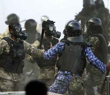A Maldives police officer, in blue, charges soldiers during a clash in Male, Maldives, Tuesday, Feb. 7, 2012. Maldives President Mohamed Nasheed presented his resignation in a nationally televised address Tuesday afternoon after police joined the protesters and then clashed with soldiers in the streets. AP Photo