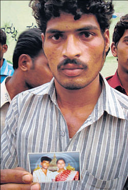 Hanumanth holds a picture of his cousin, Nagaraj, who was killed in the accident. DH PHOTO