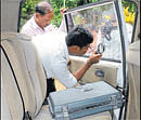 A forensic expert inspects the car after the robbery at RT&#8200;Nagar in Bangalore on Monday. DH Photo