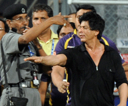Bollywood actor and Indian Premier League franchise Kolkata Knight Riders co-owner Shah Rukh Khan (R) gestures towards a security guard blowing a whistle to direct children accompanying him off the playing field after the IPL Twenty20 cricket match between Mumbai Indians and Kolkata Knight Riders at The Wankhede Stadium in Mumbai early May 17, 2012. AFP