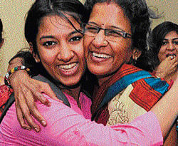 Raveena B Jain, the commerce topper, is greeted by her mother Meena Jain in Bangalore on Wednesday. dh photo