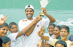 three cheers: (Left) Children surround second seed Vishnu Vardhan as he holds Zuari Garden&#8200;City ITF&#8200;Mysore Open trophy aloft at Mysore Tennis Club Courts in Mysore on Saturday. (