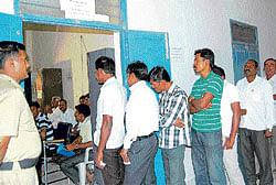 Teachers franchise: The voters wait in a queue for their turn at a polling booth in Bagepalli on Sunday. DH Photo