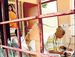Shattered: Only two of the receptionists are seen in the damaged cabin at the entrance of the Nithyananda Ashram in Bidadi on Tuesday. dh photos