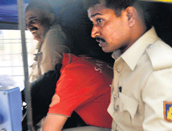 Pascal Mazurier (in red)  being taken by the police in an autorickshaw from Bowring Hospital on Friday. DH Photo