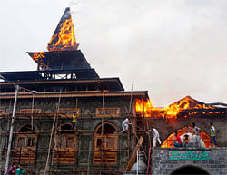 Kashmiri residents try to put out a fire at the nearly 200-years-old Sheikh Abdul Qadir Jeelan Shrinei, popularly known as Ghaus-e-Azam, or Dastgeer Sahab, in downtown Srinagar on Monday. AP