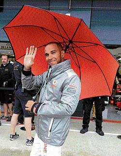 delighted: McLarens Lewis Hamilton walks through the pitlane after posting the fastest free practice time ahead of the British Grand Prix at Silverstone on Friday. AFP