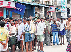 Migrant workers wait in a queue for jobs in Bellary. DH Photo