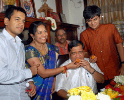 Newly sworn-in Karnataka Chief Minister Jagadish Shettar is offered sweets by his wife Shilpa and their sons at his office at Vidhan Soudha in Bengaluru on Thursday. PTI