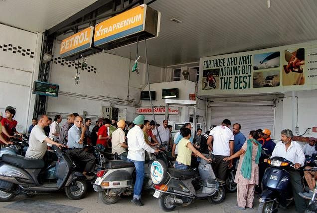 File photo of people waiting in queue at a petrol pump. PTI