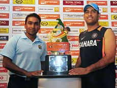 Sri Lankan cricket team captain Mahela Jayawardene (L) and Indian cricket team captain Mahendra Singh Dhoni (R) pose for photographers with the ODI trophy during a press conference in Colombo on July 18, 2012. India will play five one-day internationals in Sri Lanka, starting in Hambantota on July 21, plus a one-off Twenty20 match on August 7. AFP PHOTO